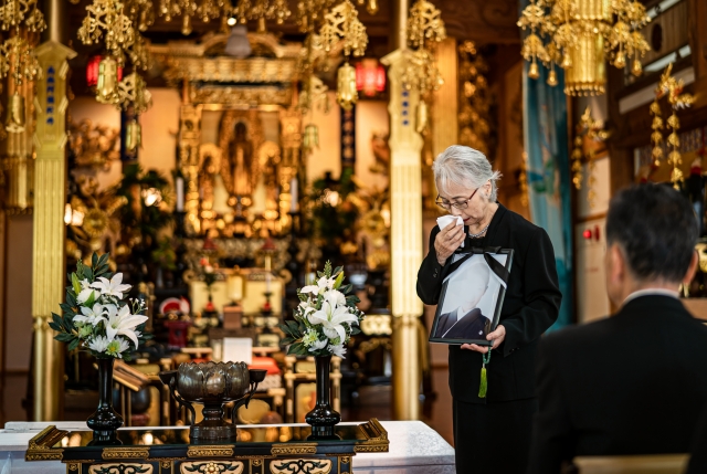 葬儀 喪主が遺影を持っている画像